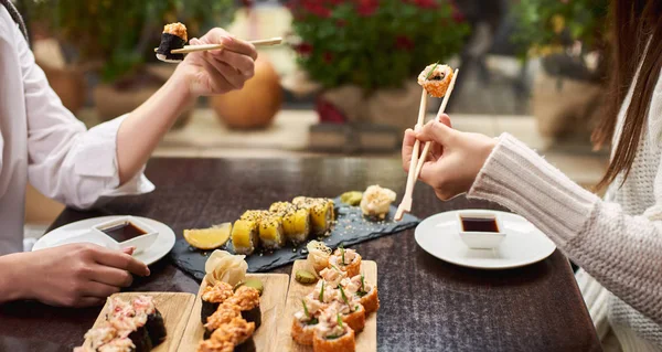 Cerca Amigas Disfrutando Sabroso Sushi Conjunto Algunos Rollos Que Sirven — Foto de Stock