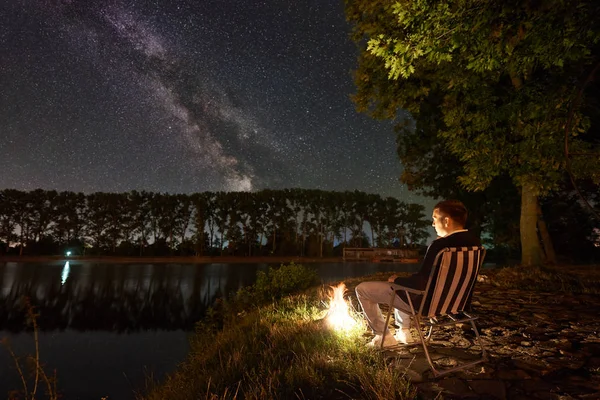 Hombre Turista Descansando Orilla Del Lago Cerca Fogata Disfrutando Una —  Fotos de Stock