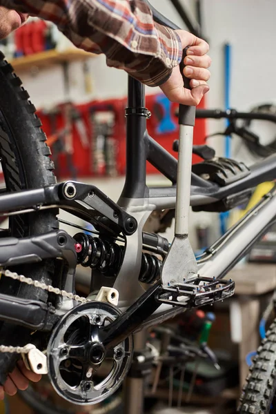 male mechanic making service in bicycle repair shop