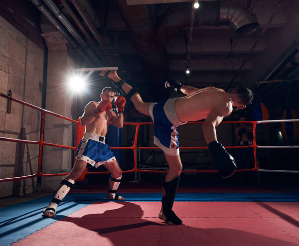 Боец, практикующий кикбоксинг с партнером по спаррингу
