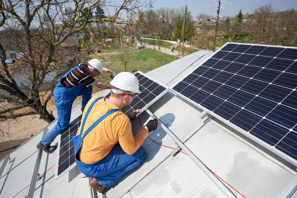 現代の家の屋根の上の青い太陽電池モジュールを取り付け電気技師 代替再生可能エネルギー生態学的な概念 — ストック写真