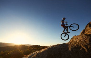 Profesyonel sporcu bisikletçi mahkemeye kayalık dağ üstüne bisiklet atlama