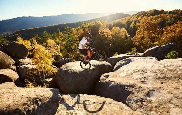 年轻的骑自行车的人在大巨石上的试车平衡 — 图库照片