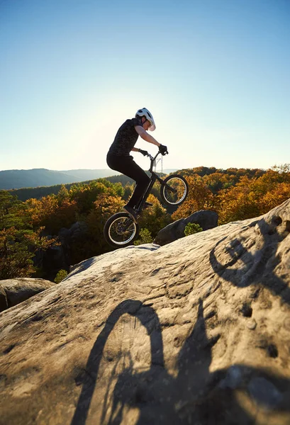 职业运动员骑自行车在岩石山上跳上试车 — 图库照片