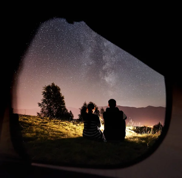年轻的幸福夫妇旅客休息附近发光的旅游帐篷 — 图库照片