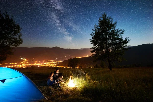 Młoda Para Odpoczynek Przy Ognisku Obok Tourist Camp Niebieski Namiot — Zdjęcie stockowe
