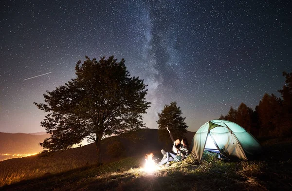 Felices Excursionistas Pareja Descansando Fogata Cerca Carpa Turística Brillante Noche —  Fotos de Stock