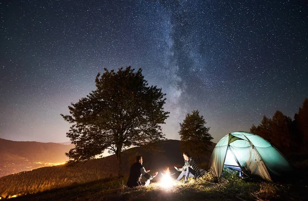 Felices Excursionistas Pareja Descansando Fogata Cerca Carpa Turística Brillante Noche — Foto de Stock
