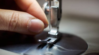 Terzi usta parmak iğneler döngü modern üretim makinesinde iplik çekerek yakın çekim 