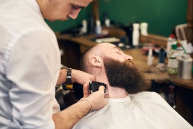 tıraş makinesi ile müşteri berber şekillendirme sakal