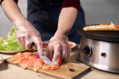 Yemek pişirmek için kesme tahtası üzerinde balık bıçak parçaları ile dilimleme Kadın eller