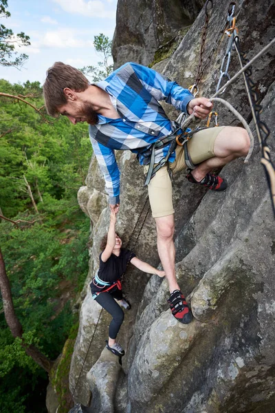 Man Helping His Friend Climbing Rock — Stock Photo, Image