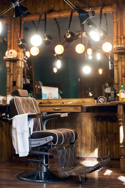 Empty barber chair in wooden interior