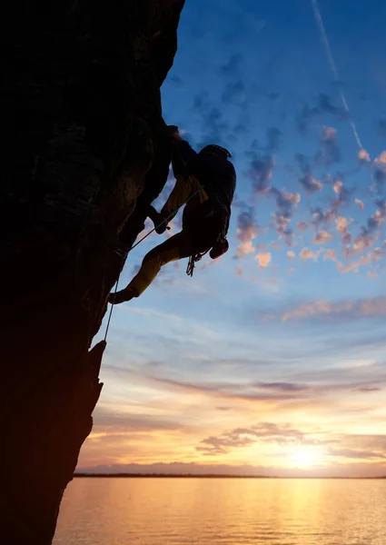 日没時に山頂まで登るスポーツマンのシルエット — ストック写真