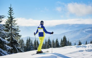 Dağın tepesinde kayak yapan bayanların arka planı karla kaplı kenarda sevinç içinde.