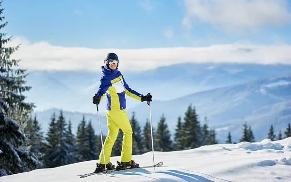 Горизонтальный Снимок Счастливой Женщины Лыжницы Стоящей Лыжах Сверху Повернутой Назад — стоковое фото