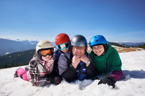 冬の木山と青空を背景にカメラで笑顔山の斜面に雪の中で登山家 女性とティーンエイジャーの子供の幸せな家族 — ストック写真