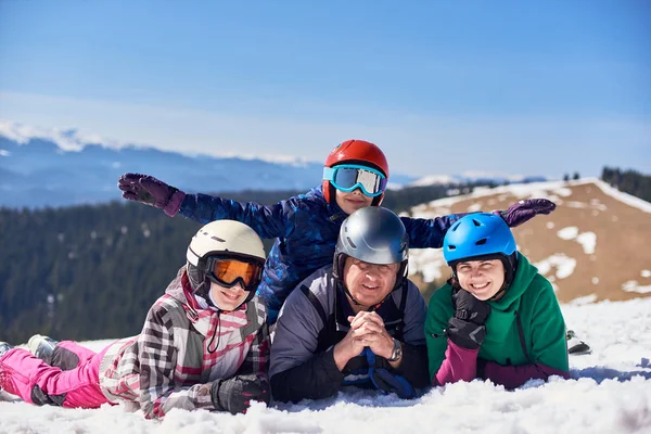 冬の木山と青空を背景にカメラで笑顔山の斜面に雪の中で登山家 女性とティーンエイジャーの子供の幸せな家族 — ストック写真