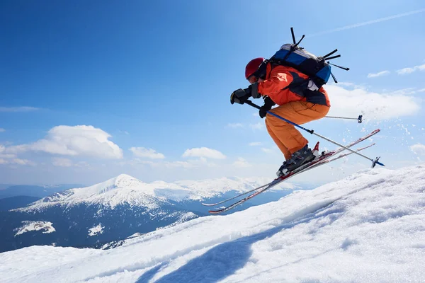 阳光明媚的日子 登山者背着滑雪板沿着雪地的山脊走着 — 图库照片