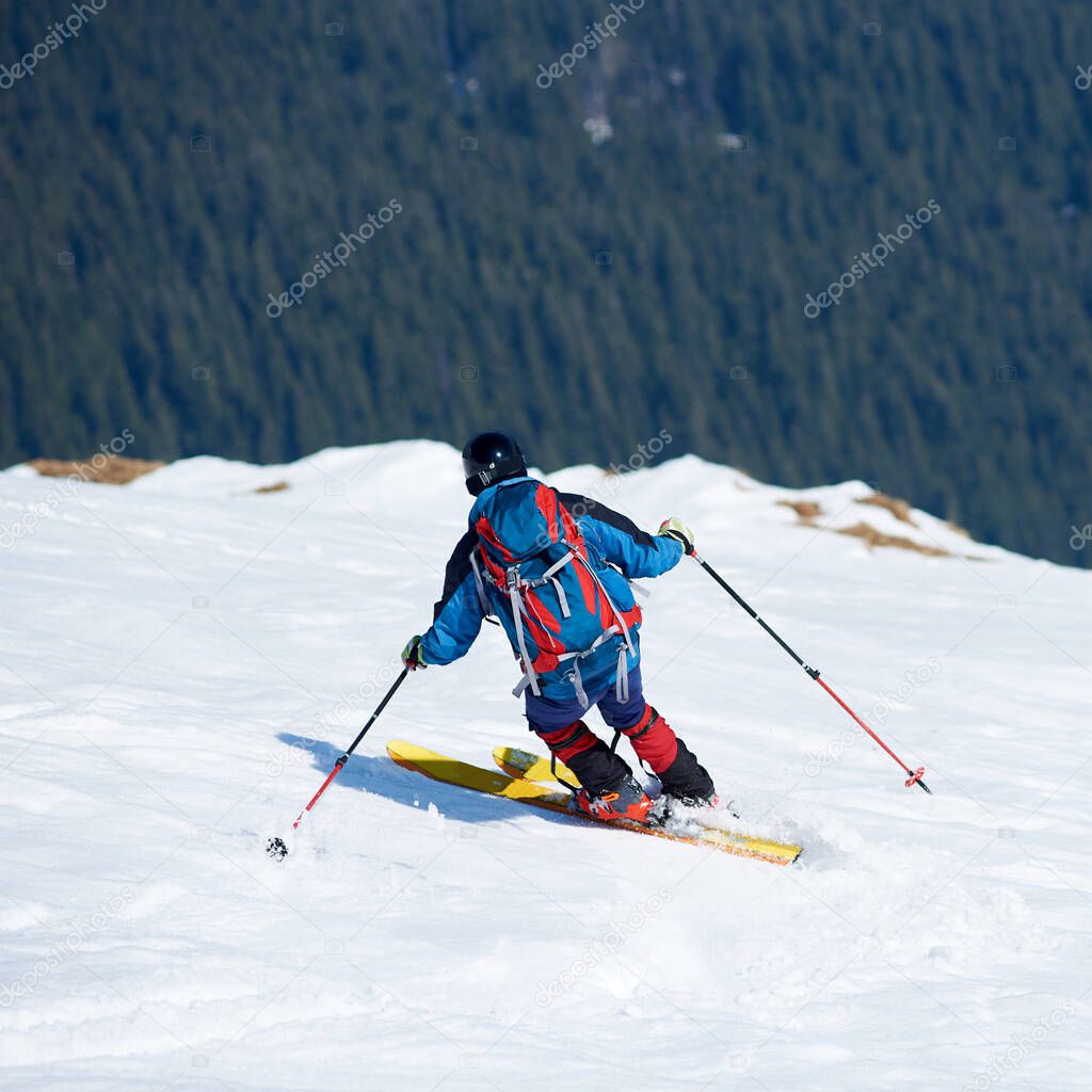 Skier hiker with backpack on skis in deep white snow on background of beautiful winter landscape