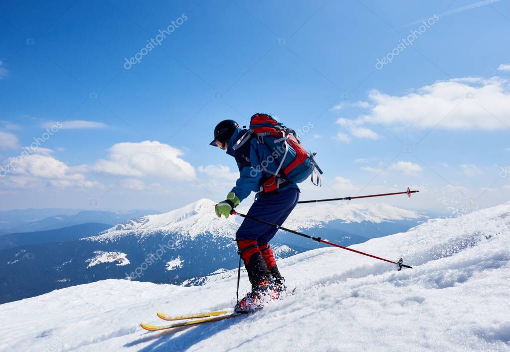 Skier hiker with backpack on skis in deep white snow on background of beautiful winter landscape