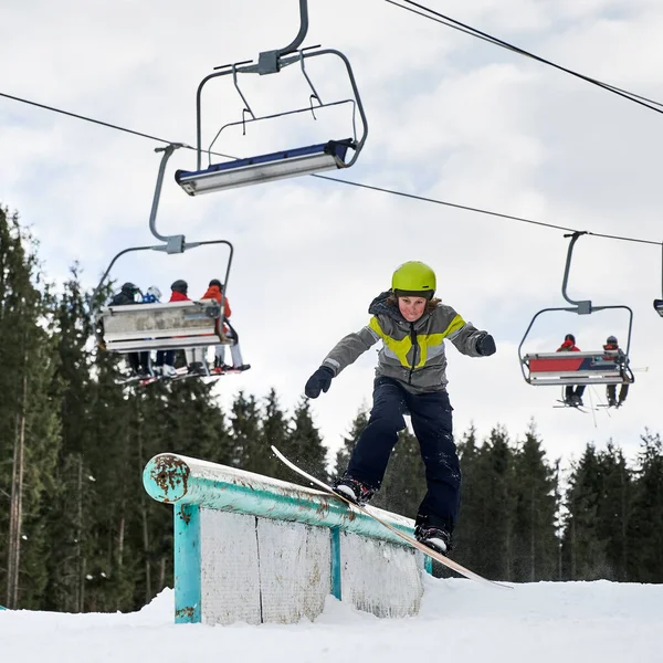 Snowboardåkare Hjälm Ridning Snowboard Skidliftar Man Utför Trick Med Snowboard — Stockfoto