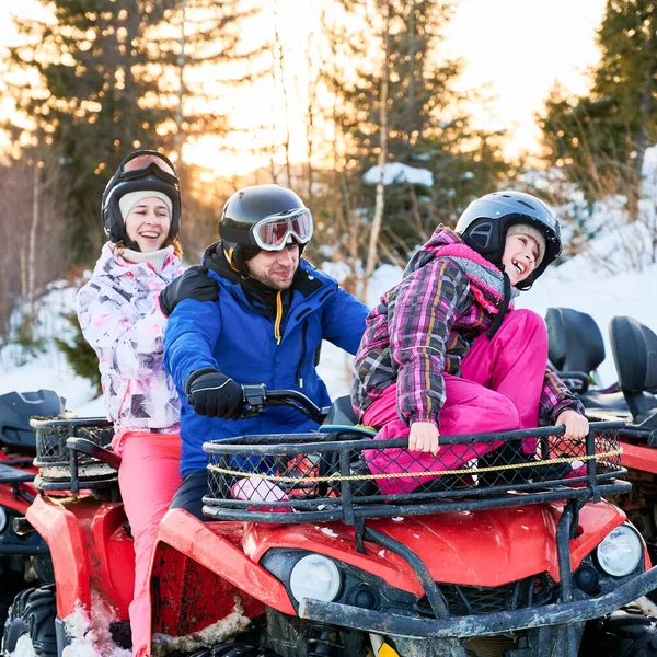 3つの幸せな家族の肖像画 カラフルなスキースーツを着て アクティブな冬の休暇を過ごす 一緒に赤いクワッドバイクで雪の山の中で笑っている 家族関係の概念 — ストック写真