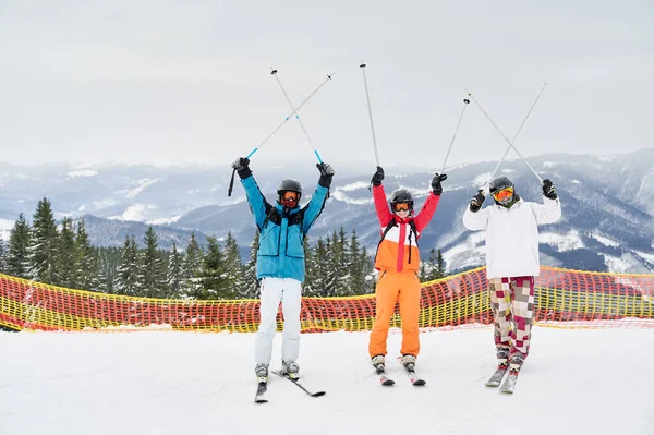 Τρεις Χαρούμενοι Τουρίστες Ποζάρουν Χιονισμένη Πλαγιά Ορεινό Φόντο Κρατώντας Ψηλά — Φωτογραφία Αρχείου