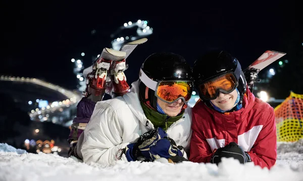 Paar Skiërs Liggen Nachts Besneeuwde Piste Onder Verlichte Stoeltjeslift Rustend — Stockfoto