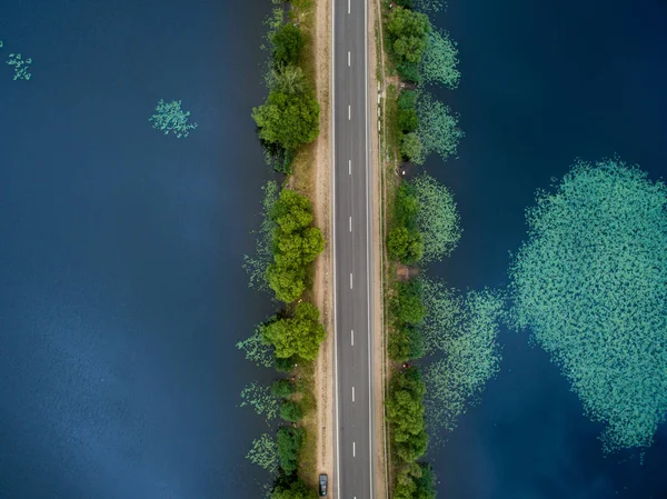 アスファルトの道路の風景です 青い川沿いに行く道の上から表示します 夏の写真 鳥の目のビュー — ストック写真