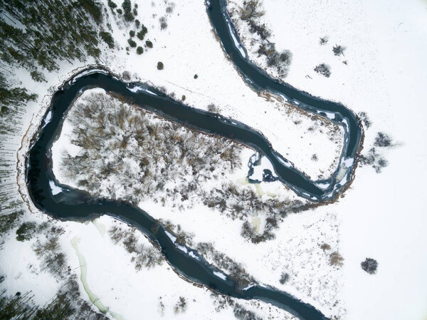 Winter landscape on the river with a forest among snow with a bird's-eye view. Drone view photo from the drone on a cloudy day. Aerial top view beautiful snowy landscape — Stock Image Winter landscape on the river with a forest among snow with a bird's-eye view. Drone view photo from the drone on a cloudy day. Aerial top view beautiful snowy landscape — Stock Photo, Image