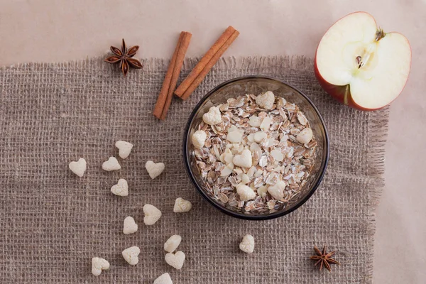 Comida saludable. Muesli en un tazón sobre un fondo claro con una manzana roja deliciosa. Gachas de desayuno sobre fondo de lino —  Fotos de Stock