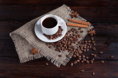Beyaz fincan kahve kahve tahıllar koyu antika arka plan üzerinde keten kumaş ile