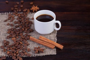 Beyaz fincan kahve kahve tahıllar koyu antika arka plan üzerinde keten kumaş ile