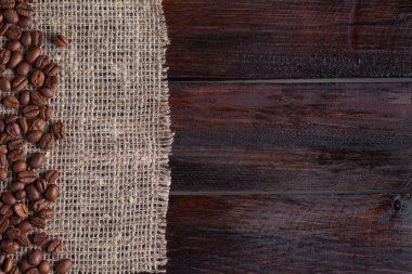 Olgun kahve taneleri keten kumaş koyu ahşap zemin üzerine. Fotoğraf Üstten Görünüm