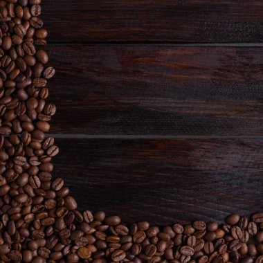 Koyu ahşap arka planda kahve taneleri. Fotoğraf üst görünümü