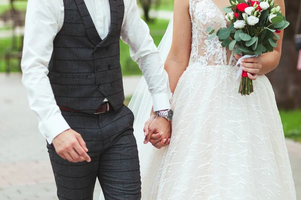 Braut und Bräutigam halten sich bei der Hochzeit sanft an den Händen, Nahaufnahme — Stockfoto