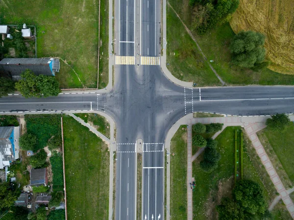 Top view asphalt road, a crossroads in the village on a bright sunny day. Aerial photo of transport junction — Stock Photo, Image