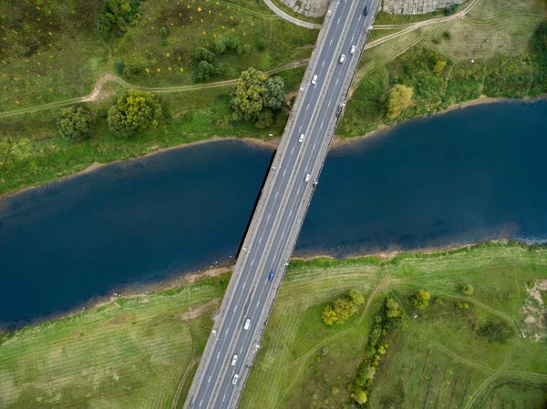 Landschap van een asfalt weg met auto's. Uitzicht vanaf boven op de brug en de blauwe rivier. Zomer fotografie met vogel's Eye View. — Gratis stockfoto