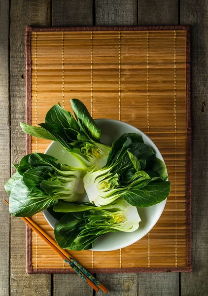 Baby bok choi on bambu placemat on rustic background — Stok Foto