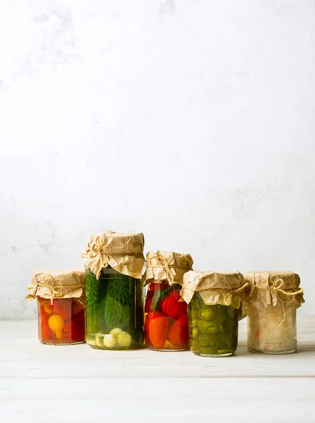 Vegetable preserves in glass jars on white background. Vertical image with copy space — Stock Photo, Image