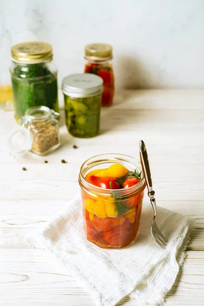 Tomat bermarinasi dalam toples kaca terbuka, berbagai macam sayuran yang diawetkan di latar belakang putih. Citra vertikal . — Stok Foto