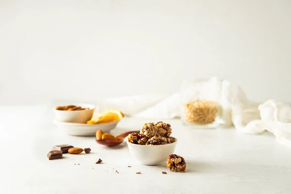 Choklad, mandel, apelsin och havregryn energi bollar i vit skål på vit bakgrund — Stockfoto