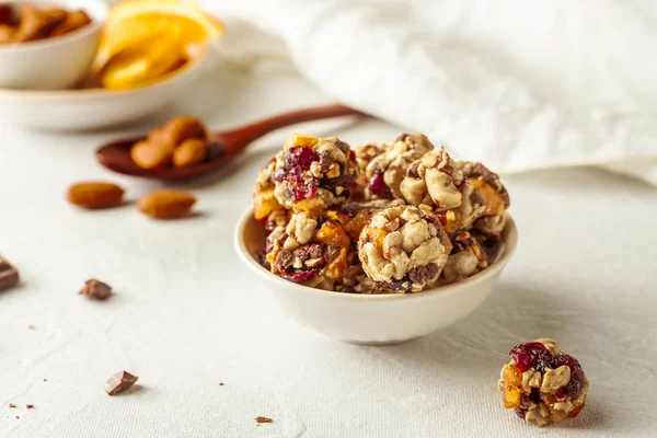 Bolas energéticas de chocolate, almendras, naranja y avena en un bol blanco sobre fondo blanco — Foto de stock gratis