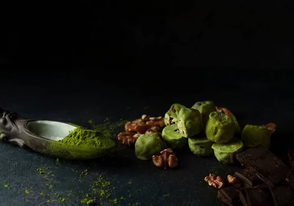 Rå energi bollar med matcha te pulver på på mörk bakgrund, framifrån. Horisontell bild. — Stockfoto