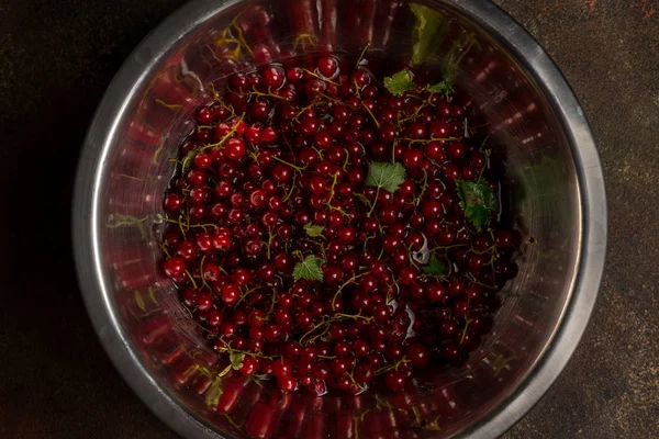 Ripe red currant berries in a bowl, top view, low key image. — Stock Photo, Image