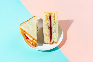 Trendy Kore sandviç inkigayo iki renkli pastel arka plan üzerinde bir tabak üzerinde, sert ışık ile vuruldu.