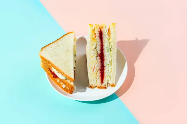 Módní korejský sendvičový šamajo na talíři na dvoubarevném pastelových pozadí, snímek s tvrdým světlem. — Stock fotografie