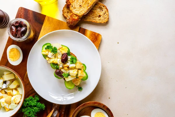 Sandwich abierto con ensalada tradicional de papa alemana, pan, todos los ingredientes sobre fondo rosa pálido, vista superior — Foto de Stock