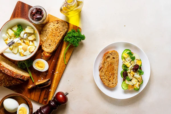 Sandwich abierto con ensalada tradicional de papa alemana, pan, todos los ingredientes sobre fondo rosa pálido, vista superior — Foto de Stock